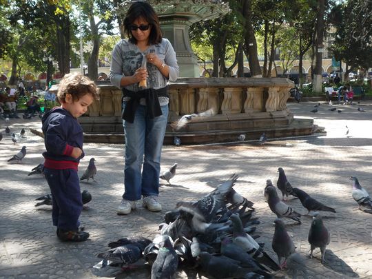 Nataly and Fabien feeding pigeons on Plaza 14 de Septiembre