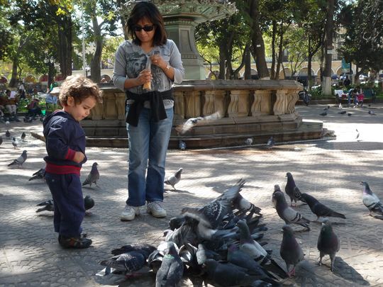 Nataly y Fabien dando comida a las palomas en la Plaza 14 de Septiembre