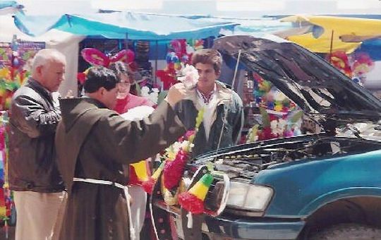 Priest baptizing a car engine