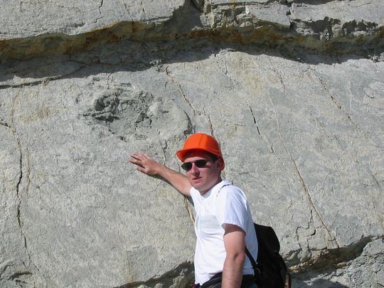 Nicolas in front of dinosaur footprints